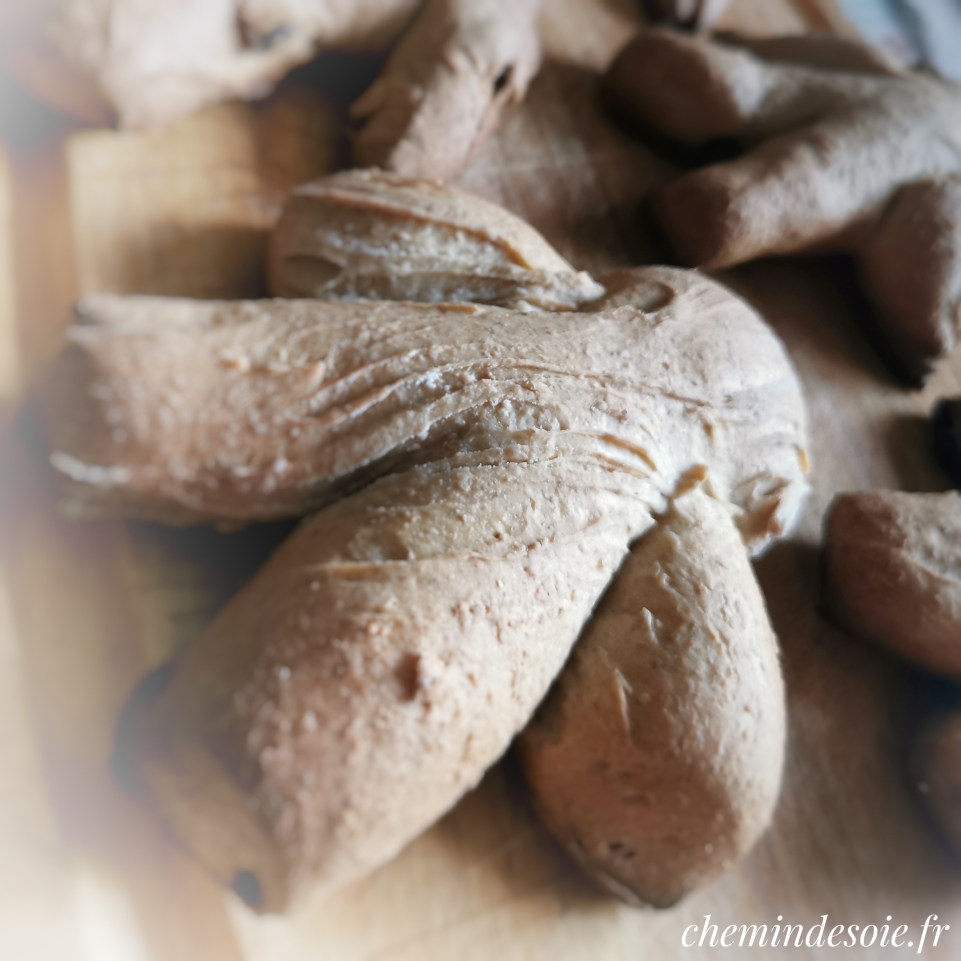 Image en gros plan de brioches en forme de bonhomme, posées sur une planche. Version retouchée : effet focus sur la "tête", et vignettage clair.